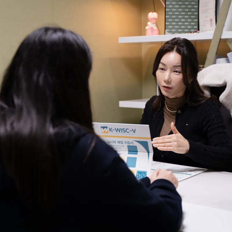 원장이 마주 앉은 내담자에게 설명하는 장면
